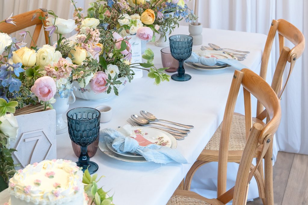 Table de mariage décorée avec bouquets colorés, vaisselle florale et verres bleus, inspiration Locatheme pour événements en Provence.